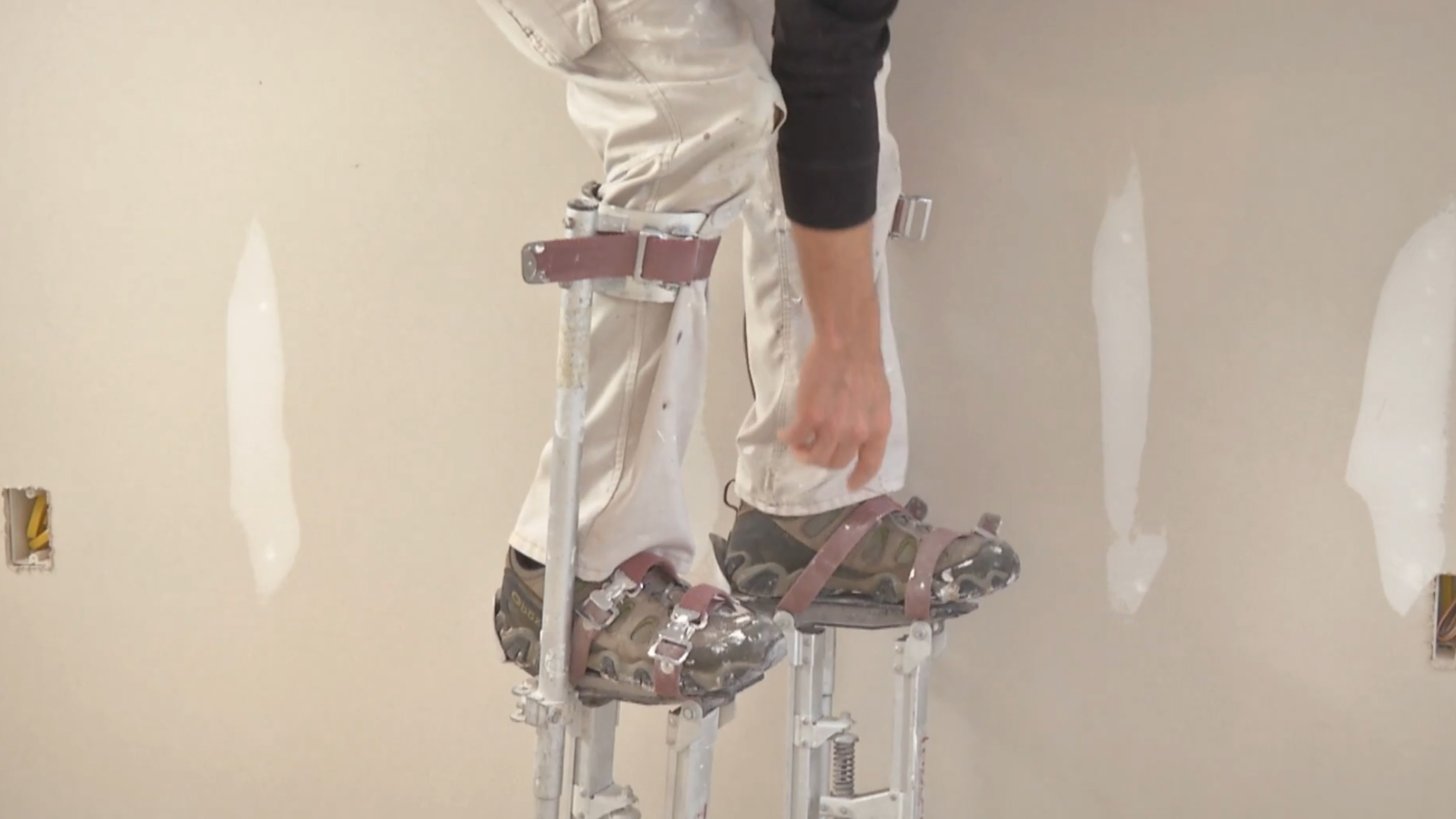 Myron climbing into a pair of metal stilts